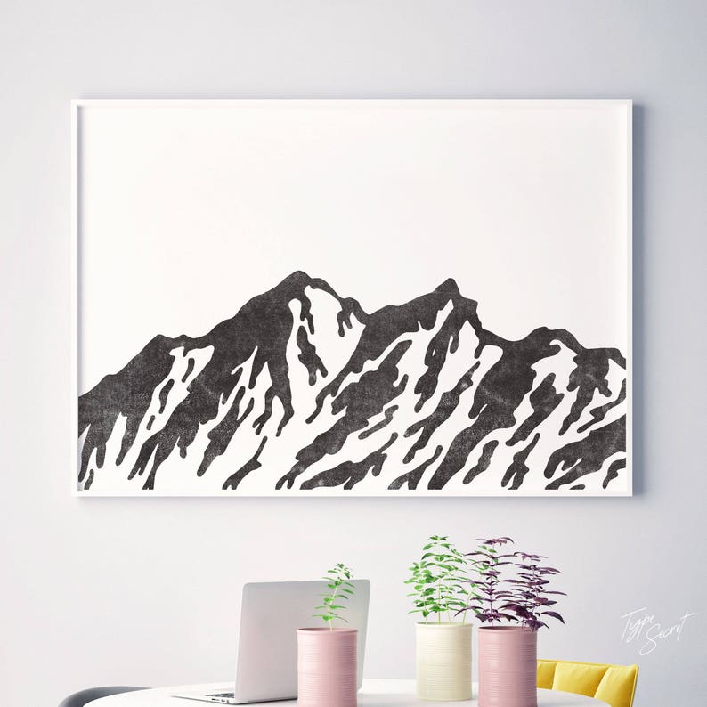 May include: Black and white minimalist print of a mountain range silhouette. The print is framed in a white frame and is hanging on a white wall.