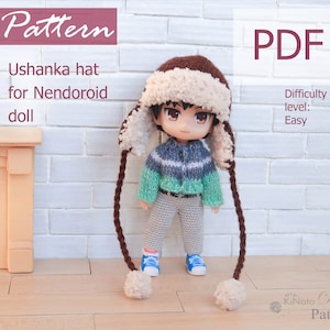 May include: A crochet pattern for a brown and white ushanka hat with long brown braids. The pattern is for a Nendoroid doll and is labeled as easy difficulty. The pattern is available as a PDF download. The text "Pattern" and "PDF" are in large, bold letters.