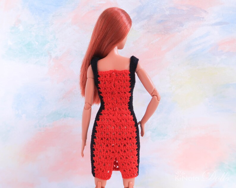 May include: A red crochet dress with black trim. The dress is sleeveless and has a fitted silhouette. The dress is shown on a doll.