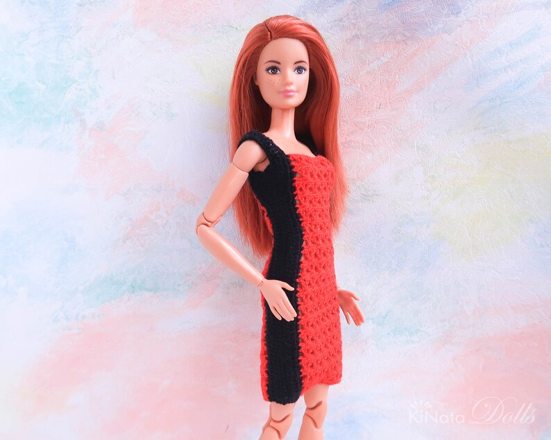 May include: A red and black crocheted dress for a doll. The dress has a black stripe down the side and a red crocheted bodice.