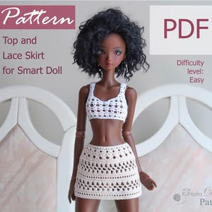 May include: A crochet pattern for a top and skirt for a Smart Doll. The pattern is for a white top and a cream skirt. The difficulty level is easy. The pattern is available as a PDF download.