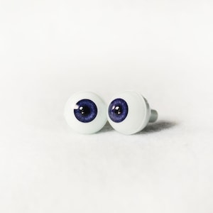 Puede incluir: Dos ojos de mu&ntilde;eca de pl&aacute;stico blanco con iris azules y pupilas negras.