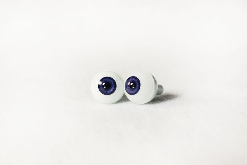 Puede incluir: Dos ojos de mu&ntilde;eca de pl&aacute;stico blanco con iris azules y pupilas negras.