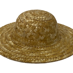May include: A wide-brimmed straw hat with a rounded crown. The hat is woven from natural straw and has a light brown colour.