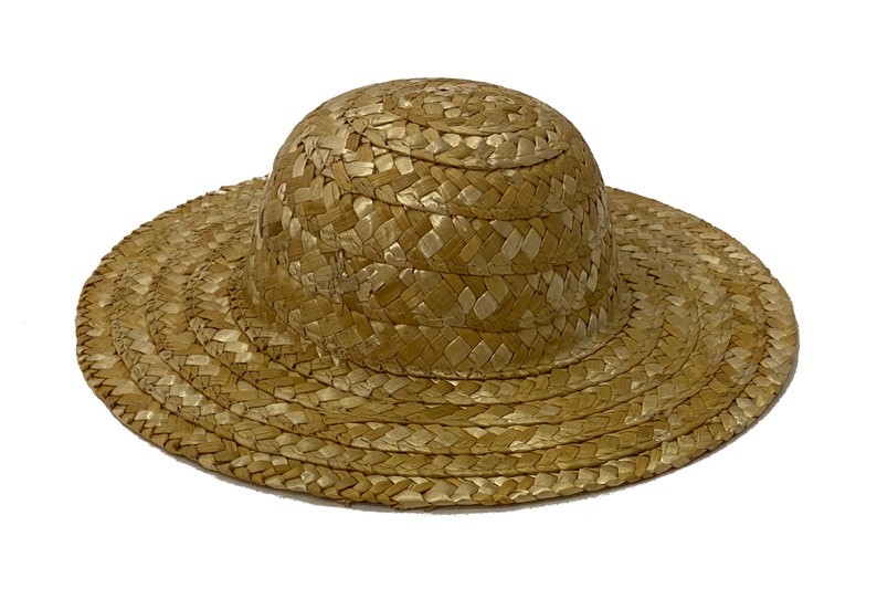 May include: A wide-brimmed straw hat with a rounded crown. The hat is woven from natural straw and has a light brown colour.