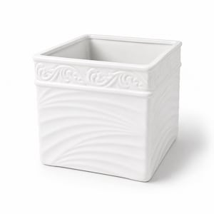 May include: A square white ceramic planter featuring a smooth interior and a textured exterior. The upper rim displays a raised scrollwork pattern, while the lower body is decorated with a series of subtle, diagonal wave-like embossed lines.