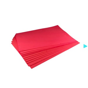 Puede incluir: Una pila de hojas rectangulares de color rojo brillante, posiblemente cartulina o papel de construcci&oacute;n, se muestra sobre un fondo blanco. Las hojas est&aacute;n cuidadosamente dispuestas, con los bordes alineados, lo que sugiere que son nuevas y sin usar.
