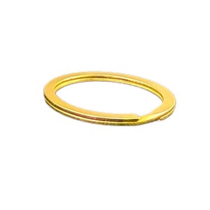 May include: A gold-colored split key ring, oval-shaped, with a small opening. The key ring is made of metal and has a shiny finish. The key ring is designed to hold keys or other small items.