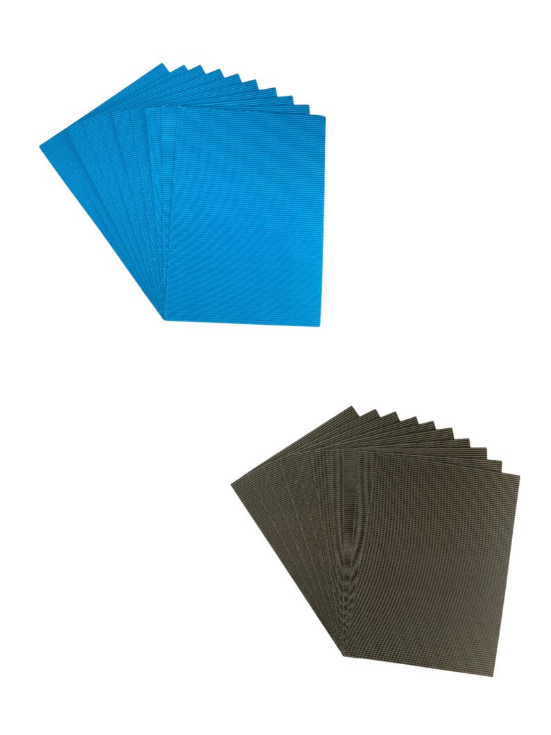May include: Two stacks of cardboard sheets, one blue and one black. The sheets are corrugated and have a textured surface.