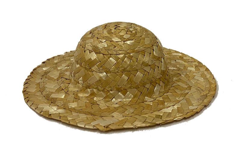 May include: A woven straw hat with a wide brim and a rounded crown. The hat is light brown in colour and has a natural, rustic look.