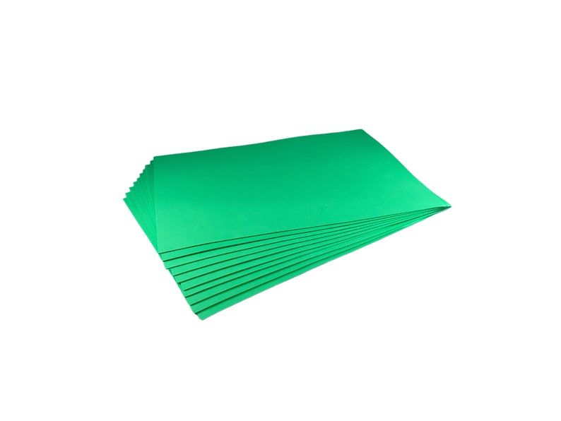 Puede incluir: Una pila de hojas rectangulares de color verde brillante, posiblemente papel o cartulina, sobre un fondo blanco. Las hojas est&aacute;n cuidadosamente dispuestas, con sus bordes visibles, lo que sugiere una presentaci&oacute;n limpia y organizada. El color es vibrante y uniforme.