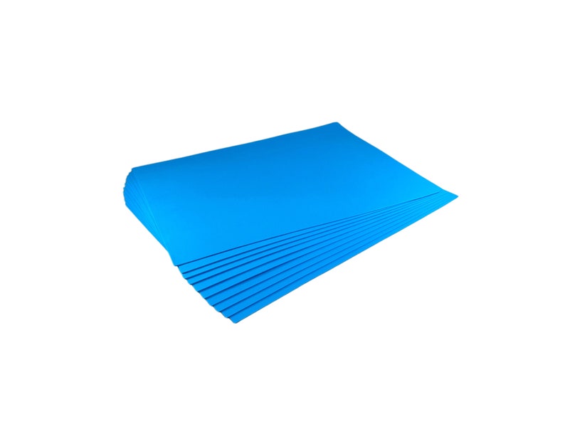 Puede incluir: Una pila de hojas de papel azul brillante, probablemente para manualidades u oficina, se muestra sobre un fondo blanco. El papel tiene una textura suave y un color s&oacute;lido vibrante. La pila est&aacute; cuidadosamente organizada.