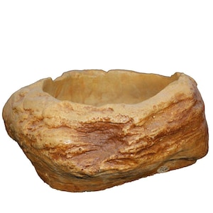 May include: A light brown, irregularly shaped, ceramic planter with a wide, shallow bowl. The planter has a rough, textured surface that resembles rock.