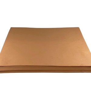 Puede incluir: Una pila de hojas de papel rectangulares de color marr&oacute;n claro. Las hojas est&aacute;n apiladas ordenadamente, con los bordes alineados. El papel tiene un acabado liso y mate y parece ser de grosor medio. El fondo es blanco liso.