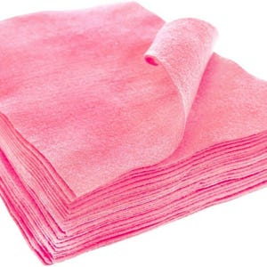 May include: A stack of pink cleaning cloths, folded and rolled up, isolated on a white background.