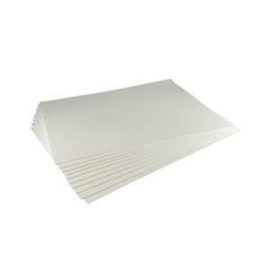 Puede incluir: Una pila de hojas de papel rectangulares de color blanquecino. El papel est&aacute; dispuesto de forma ligeramente abanicada, revelando las hojas individuales. Los bordes son limpios y el papel parece tener una textura suave.