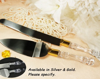 May include: A set of two cake cutting knives with clear acrylic handles and gold accents. The knives have a silver blade and are available in silver or gold.  Available in Silver & Gold. Please specify.