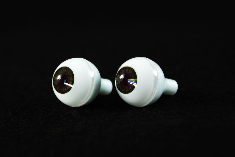 Puede incluir: Dos ojos de vidrio de aspecto realista con iris marrones y escler&oacute;ticas blancas. Los ojos est&aacute;n montados en bases de pl&aacute;stico blanco con un peque&ntilde;o agujero para la fijaci&oacute;n.