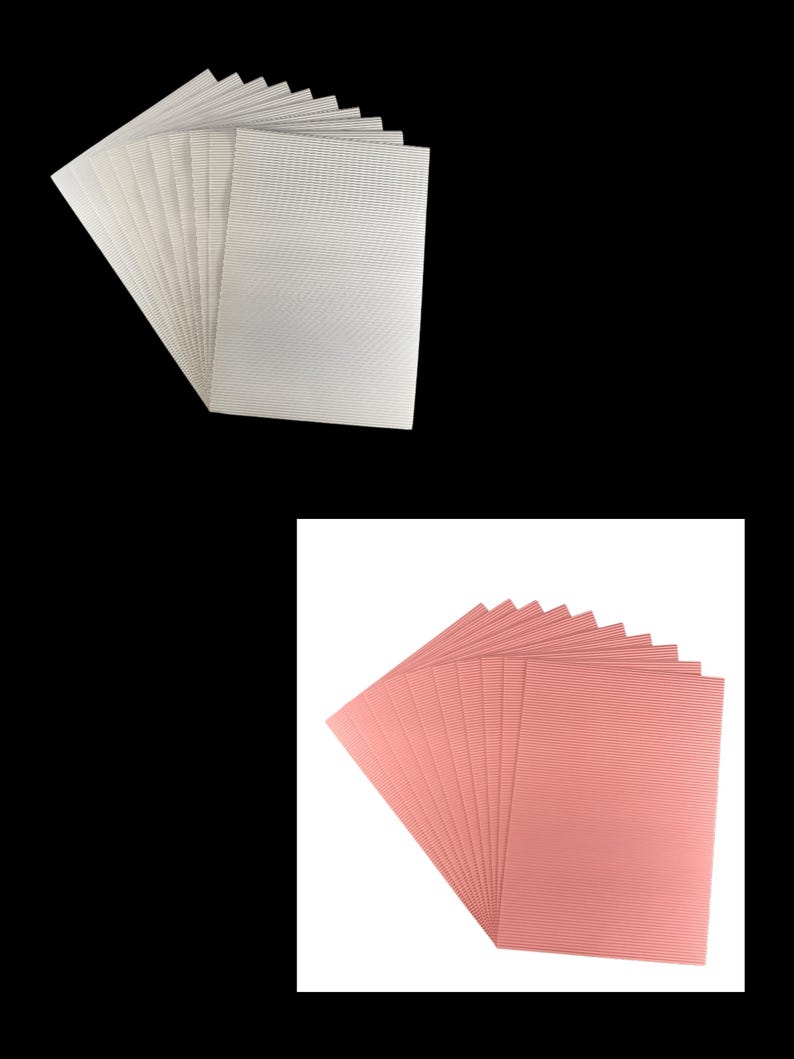 May include: Two stacks of corrugated cardboard sheets. One stack is white and the other is pink.