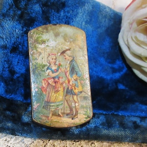 May include: A rectangular, antique, hand-painted box featuring a romantic scene of a man and woman in period clothing. The box has a distressed finish, with a blue, yellow, and pink color palette. The background shows a garden setting.