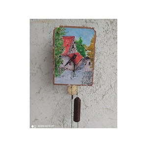 A hand-painted Soviet-era wall clock from the 70s that gives a vintage experience with a painted watermill,working, rarity, colorful piece