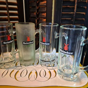 Juego de 4 jarras de cerveza Heineken vintage, con el clásico logotipo del molino de viento y bases de vidrio grueso. imagen 1