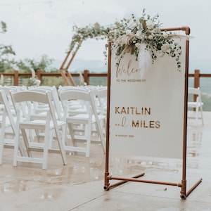 Acrylic Wedding Welcome Sign with customizable laser cut text in Gold Mirror Acrylic. Copper Stand holds Welcome Sign.