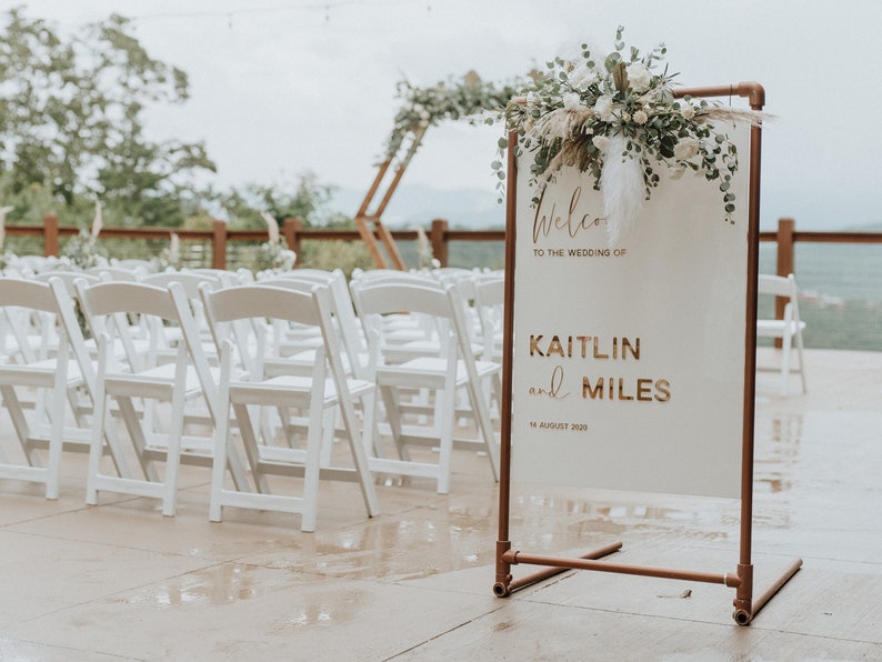 Acrylic Wedding Welcome Sign with customizable laser cut text in Gold Mirror Acrylic. Copper Stand holds Welcome Sign.