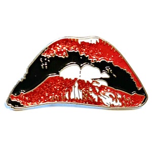 May include: Red and black enamel pin shaped like a pair of lips with a white outline. The lips are slightly parted, revealing a white space between them.