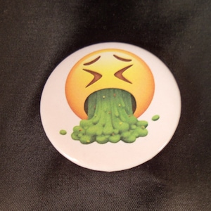 May include: A yellow emoji face with a green vomit coming out of its mouth. The emoji has a distressed expression with its eyes closed and mouth open.