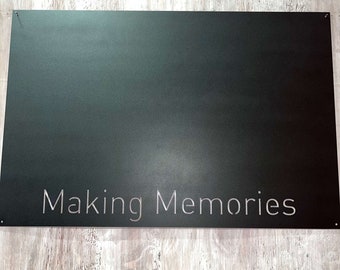 May include: A black metal sign with the words "Making Memories" etched in silver lettering.