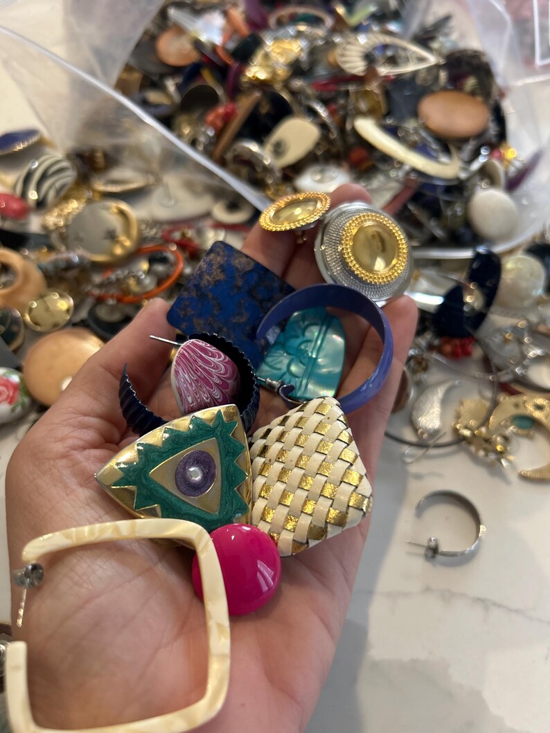 Puede incluir: Una colecci&oacute;n de pendientes vintage de diversas formas, colores y materiales. Los pendientes incluyen formas geom&eacute;tricas, dise&ntilde;os tejidos y piedras de colores.