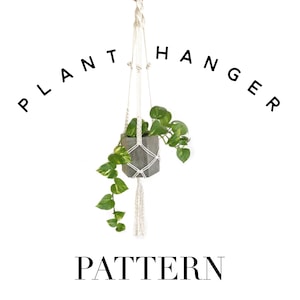 Op de afbeelding: Een witte macramé plantenhanger met een grijze betonnen pot en een groene plant die eraan hangt. De tekst "PLANT HANGER PATTERN" staat in zwarte letters boven en onder de hanger.