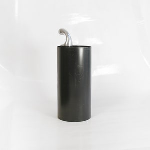 May include: A black cylindrical container with a silver hook on top. The container is made of metal and has a smooth surface.