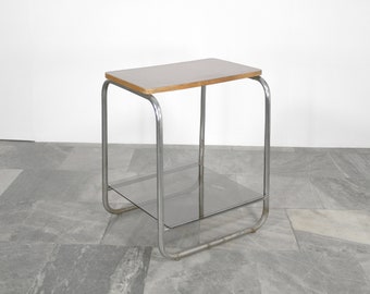 May include: A chrome side table with a wood top and a glass shelf. The table has a simple, modern design.