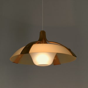 May include: A white and brown pendant light with a white frosted glass shade and wooden accents. The light is hanging from a white cord.
