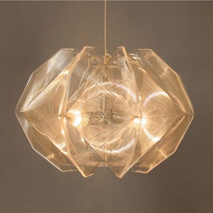 Könnte beinhalten: Eine klare, geometrische Pendelleuchte mit gewebtem Design. Die Leuchte ist aus Acryl und hat einen modernen, minimalistischen Stil.