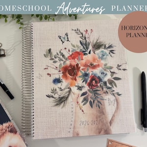 May include: A spiral-bound homeschool planner with a floral design in a neutral color palette. The cover features a watercolor illustration of flowers in a pitcher, with the text "2026-2027". The planner is labeled "Homeschool Adventures Planner" and "Horizontal Planner".