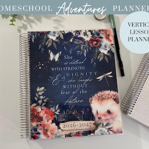 May include: A spiral-bound homeschool planner with a navy blue cover featuring floral illustrations, a hedgehog, and a butterfly. The text reads "She is clothed with strength and dignity, she laughs without fear of the future." The planner is labeled "2026-2027".