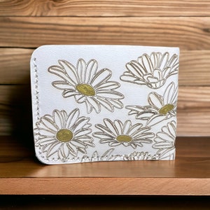 Cartera plegable de cuero con margaritas en blanco y dorado