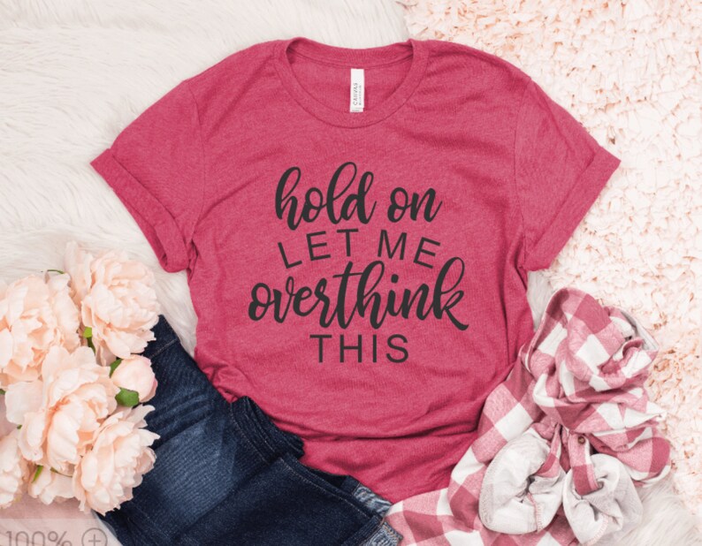 May include: A pink t-shirt with the text "hold on let me overthink this" in black script.