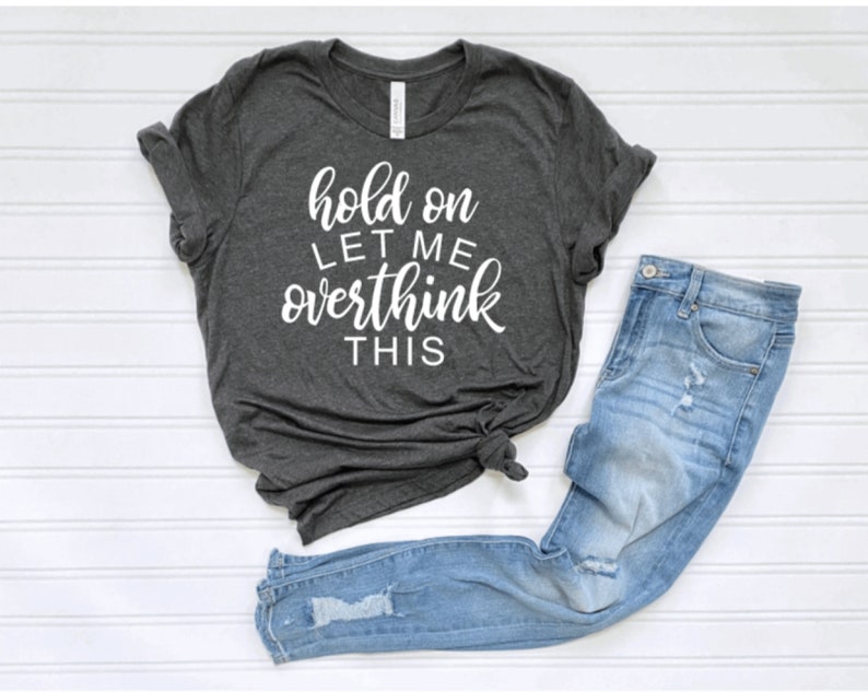 May include: A dark gray t-shirt with the text "hold on let me overthink this" in white lettering.