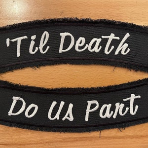 May include: Two black fabric patches with white embroidered text. The top patch says "'Til Death" and the bottom patch says "Do Us Part".