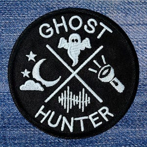 May include: Black and white embroidered patch with the text "Ghost Hunter" and a ghost, crescent moon, and flashlight design.