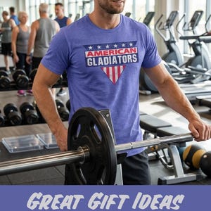 以下が含まれることがあります： ジムで、白い文字と赤い文字で「AMERICAN GLADIATORS」と書かれた青いTシャツを着た人。シャツは愛国的なデザインです。画像には「GREAT GIFT IDEAS FOR CLASSIC TV SHOW LOVERS IN YOUR LIFE」というテキストも含まれています。