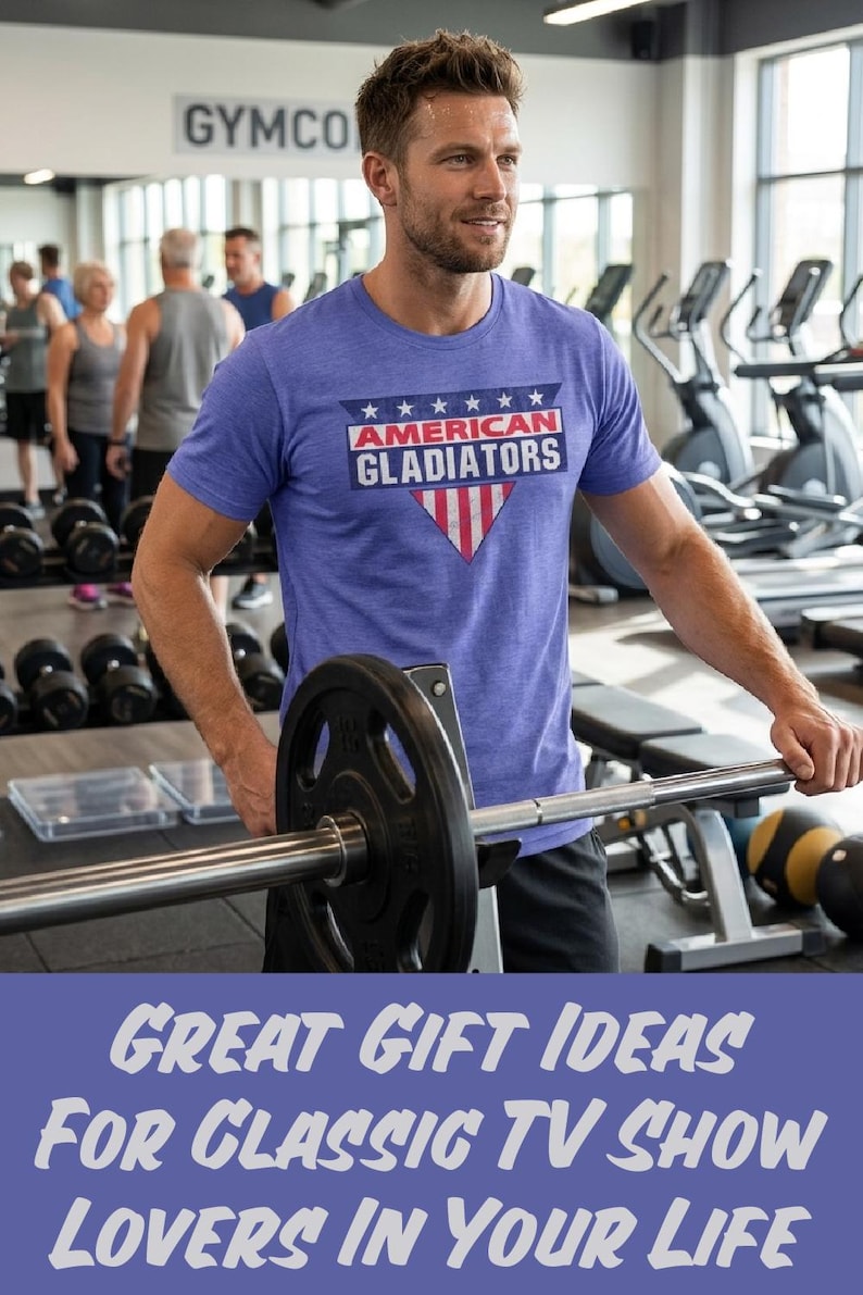 以下が含まれることがあります： ジムで、白い文字と赤い文字で「AMERICAN GLADIATORS」と書かれた青いTシャツを着た人。シャツは愛国的なデザインです。画像には「GREAT GIFT IDEAS FOR CLASSIC TV SHOW LOVERS IN YOUR LIFE」というテキストも含まれています。