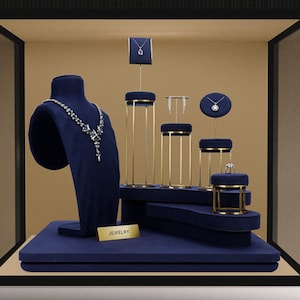 May include: A blue velvet jewelry display with gold metal stands and a variety of necklaces, earrings, and rings. The display is labeled "JEWELRY".