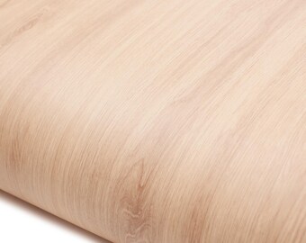 May include: Close-up of a light-colored wood grain pattern. The wood has a natural, warm tone with visible grain lines and a slight curve, suggesting a rolled or curved surface.
