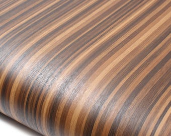 May include: Close-up of a curved surface with a wood grain pattern. The surface has alternating dark brown and light brown vertical stripes. The wood grain appears to be smooth and glossy.