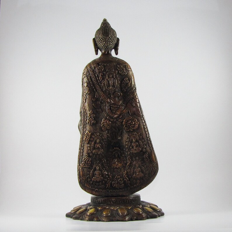 May include: A bronze statue of a Buddha, seated in a meditative pose. The statue is intricately detailed with a patterned robe and a lotus base.